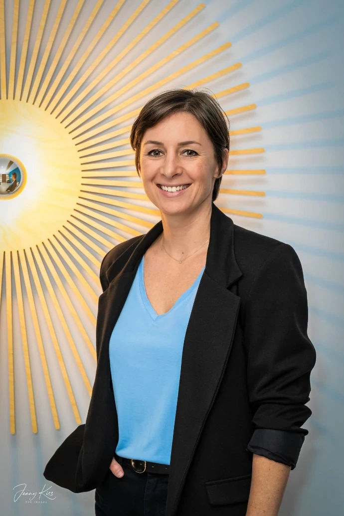 Professionelles Foto einer Unternehmerin in einem modernen Ambiente, das Kreativität, Persönlichkeit und Selbstsicherheit vermittelt.